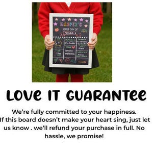 May include: A chalkboard sign with a white frame held by a person. The sign reads "HARPER'S FIRST DAY OF YEAR 1" with colorful illustrations and text. The sign includes the date 1/09/2025 and other details.