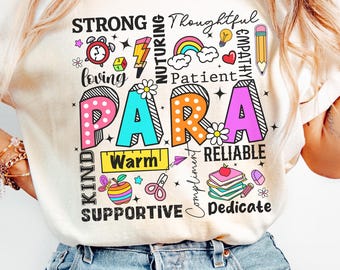 May include: Cream-colored t-shirt with the word "PARA" in large, colorful letters. Surrounding the word are smaller words like "Strong," "Loving," "Kind," and "Supportive." The shirt has a casual, relaxed fit.
