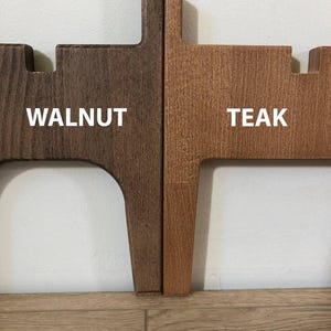May include: A side-by-side comparison of two wooden pieces, one walnut and one teak. The walnut piece is a dark brown, while the teak piece is a lighter, reddish-brown. The text "WALNUT" and "TEAK" are displayed in white.