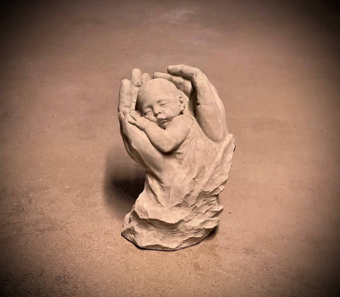 Statue of Two Hands Holding Baby