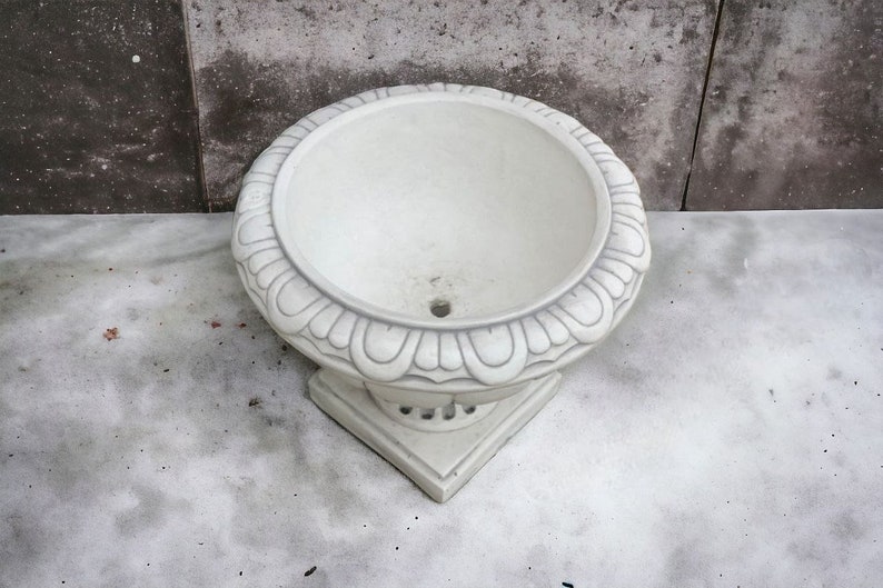 May include: White ceramic planter with a decorative, scalloped rim and a round base. The planter is empty and ready for planting.