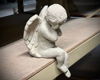 Weeping angel figure Faceless cherub statue Concrete sitting angel hiding face sculpture