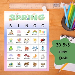 May include: A colorful spring-themed bingo game with the word "SPRING" at the top. The bingo card features spring-related images like flowers, insects, and outdoor activities. A notepad with "30 5x5 Bingo Cards" is also visible.