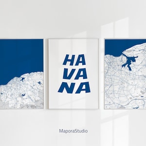 May include: Three framed prints with a map theme. Two prints feature a blue and white map design, while the central print displays the word "HAVANA" in bold blue letters. The prints are displayed on a white wall.