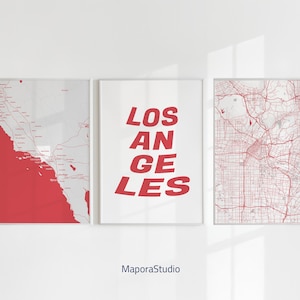 May include: Three framed art prints. The left print features a red and white map of a coastal region. The center print has the words "LOS ANGELES" in red. The right print displays a red and white city map. All are framed in white.