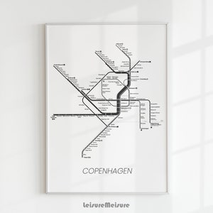 Op de afbeelding: Een zwart-witte metrokaart van Kopenhagen, Denemarken. De kaart toont de verschillende lijnen en stations van het metrosysteem van de stad. De kaart is ingelijst en klaar om aan de muur te hangen.