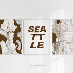 May include: Three framed prints with a brown background. The left and right prints feature a black and white map of Seattle. The centre print features the word "SEATTLE" in brown letters.