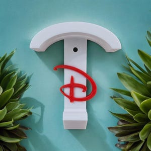 May include: White wall-mounted hook with a red Disney logo. The hook is shaped like a T with a curved top.