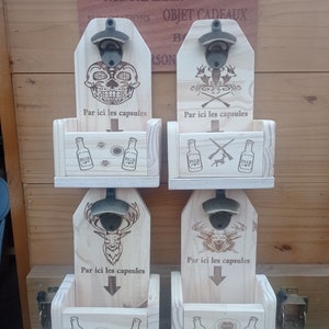 Peut inclure: Quatre ouvre-bouteilles en bois avec un compartiment pour les capsules de bouteilles. Chaque ouvre-bouteille présente un design différent : un crâne, une scène de chasse, un cerf et un ours. Le texte "Par ici les capsules" est gravé sur chaque ouvre-bouteille.