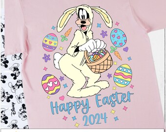 May include: Pink t-shirt featuring a cartoon character dressed as a bunny holding a basket of Easter eggs. The shirt has the text "Happy Easter 2024" with colorful Easter-themed graphics. The design includes the text "Digital Designs Illustrated by Rachel" and "PNG ONLY".