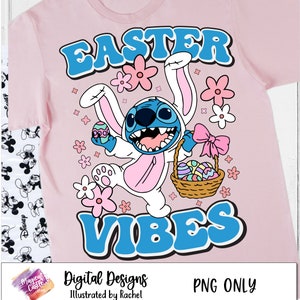 Puede incluir: Una camiseta rosa con un personaje de dibujos animados azul y blanco que lleva un disfraz de conejo. El personaje sostiene una cesta de huevos de Pascua. El texto "Easter Vibes" est&aacute; escrito en letras azules en la camiseta.