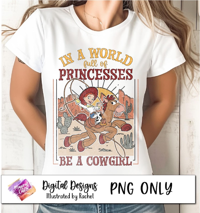 May include: A white t-shirt with a vintage-style graphic featuring a cartoon cowgirl riding a horse. The text reads "In a world full of princesses, be a cowgirl".