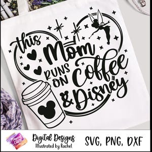 Op de afbeelding: Witte draagtas met een zwarte afbeelding met de tekst "This Mom Runs On Coffee & Disney". Het ontwerp bevat een koffiekopje met een Mickey Mouse-hoofd, harten, sterren en een silhouet van Tinkerbell.