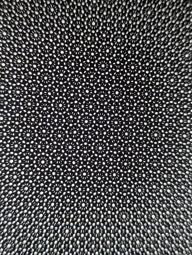 May include: A black and white abstract pattern with a circular design. The pattern is made up of small circles and dots, creating a repeating design.