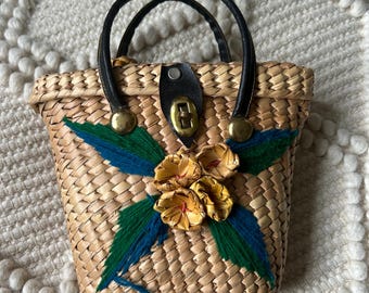 Bolso pequeño vintage de algas marinas tejidas, con detalles florales y asas de cuero.