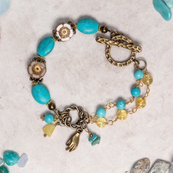 Modèle asymétrique turquoise, citrine et bronze, bracelet fait main avec perles focales de fleurs d'hibiscus et fermoir à bascule et breloque Gyan Mudra