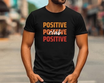 May include: A black t-shirt with the text "POSITIVE club POSITIVE" printed in orange, yellow, and red.
