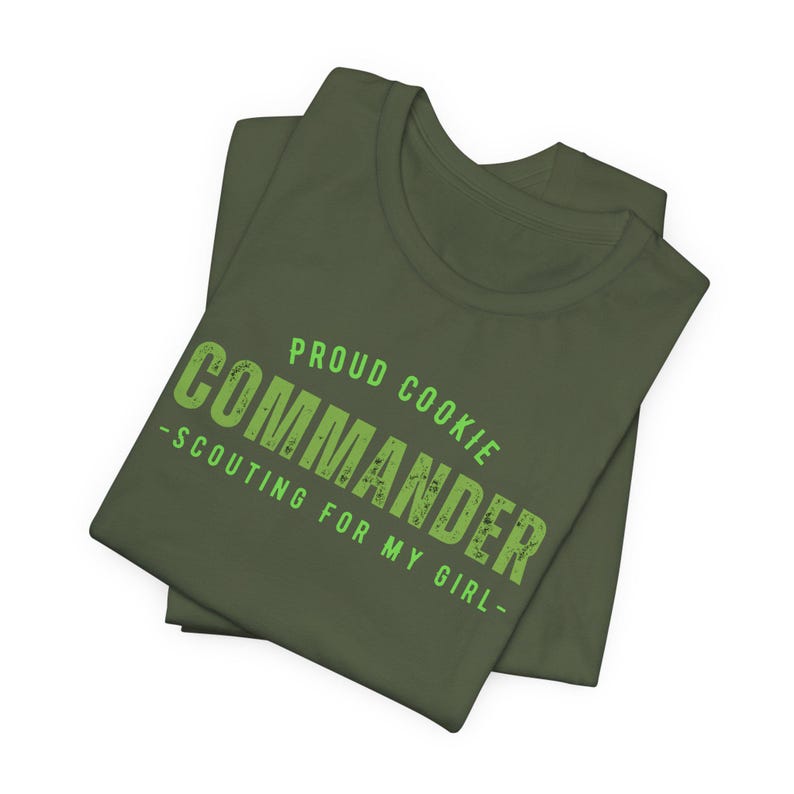 Może przedstawiać: Zielony T-shirt z napisem "Proud Cookie Commander - Scouting for my girl -" w kolorze zielonym.