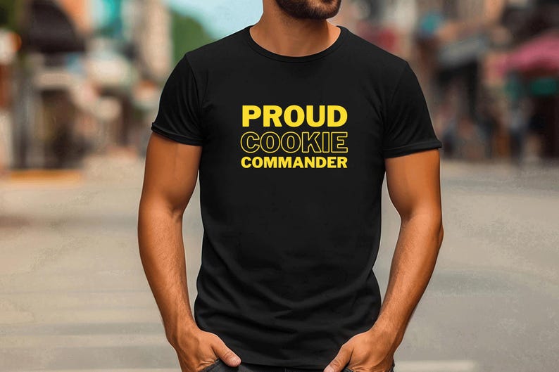 May include: A black t-shirt with the text "PROUD COOKIE COMMANDER" in yellow letters.