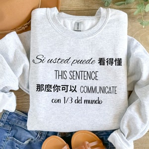 May include: Gray sweatshirt with black text that reads "Si usted puede 看得懂 THIS SENTENCE 那麼你可以 COMMUNICATE con 1/3 del mundo".