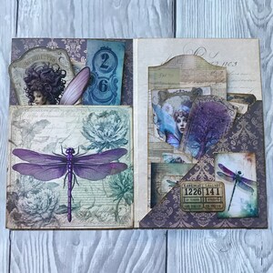 Puede incluir: Scrapbook abierto con un dise&ntilde;o de lib&eacute;lula p&uacute;rpura, detalles florales y elementos ef&iacute;meros vintage. Las p&aacute;ginas presentan bolsillos que contienen tarjetas con im&aacute;genes de mujeres, n&uacute;meros y boletos. La paleta de colores incluye p&uacute;rpura, azul y crema.