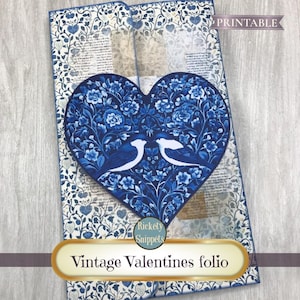 May include: A blue and white floral patterned folio with a heart-shaped design featuring two birds. The folio is labeled "Vintage Valentines folio" and is marked "Printable".