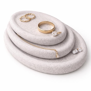 Può includere: Un set di tre tazze in ceramica con finitura opaca e macchiettata. Le tazze sono nei toni del crema, grigio chiaro e grigio scuro. Ogni tazza ha un design semplice e minimalista.