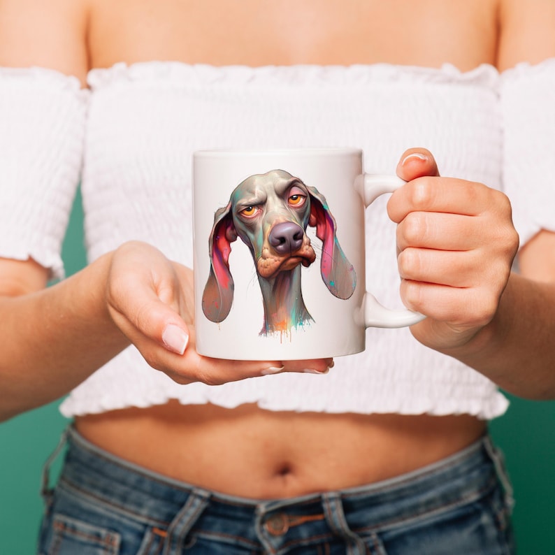 May include: White ceramic mug with a colorful illustration of a dog with a serious expression. The dog has large floppy ears and a long snout.