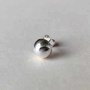 May include: A silver ball earring with a post and a back.