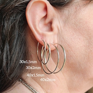 Peut inclure: Une tasse en céramique blanche avec une anse noire et le texte "But First, Coffee" en gras noir. La tasse contient un liquide foncé, probablement du café, et repose sur une surface claire.