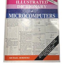 Może przedstawiać: Zbliżenie na stronę książki zatytułowanej "The Illustrated Dictionary of Microcomputers, 2nd Edition". Strona zawiera szczegółowe wyjaśnienie kodu dziesiętnego binarnego (BCD) i przetwarzania wsadowego, a także tabelę przedstawiającą wartości dziesiętne i BCD dla liczb od 0 do 6. Książka definiuje i wyjaśnia ponad 8 000 terminów związanych z mikrokomputerami, w tym prawie 4 000 nowych wpisów w tej edycji.