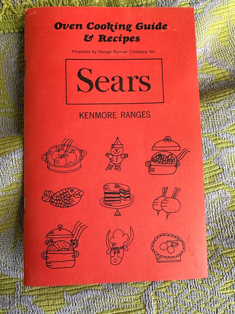 May include: A red booklet with the title "Oven Cooking Guide & Recipes" and the logo "Sears Kenmore Ranges". The cover features illustrations of various foods, including a fish, a cake, and a pie.