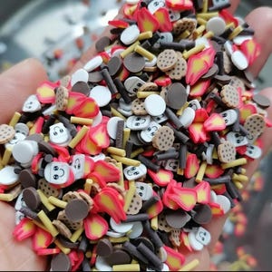 May include: A variety of colorful polymer clay sprinkles in the shape of marshmallows, graham crackers, chocolate, and flames. These sprinkles are perfect for decorating cakes, cupcakes, and other desserts.