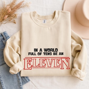 Be an Eleven Sweatshirt – In a World Full of Tens Quote Crewneck