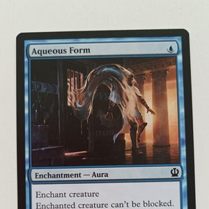 May include: Aqueous Form Magic: The Gathering card featuring a blue enchantment aura with the text "Enchant creature Enchanted creature can't be blocked. Whenever enchanted creature attacks, scry 1. (Look at the top card of your library. You may put that card on the bottom of your library.)"