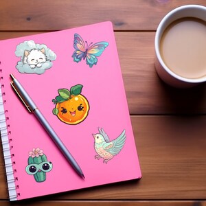 Pode incluir: Um caderno rosa com espiral e uma variedade de adesivos coloridos. Os adesivos incluem um gato dormindo em uma nuvem, uma borboleta, uma laranja sorridente, um cacto de &oacute;culos de sol e um p&aacute;ssaro.