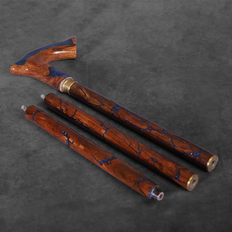 May include: A wooden walking stick with a blue and brown marbled design. The stick is adjustable and has a curved handle.