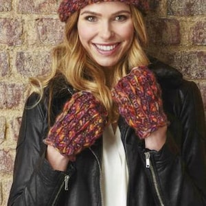 May include: A knitted hat with a pom-pom and matching fingerless gloves. The hat and gloves are a mix of red, orange, and purple yarn. The person is wearing a black leather jacket and a white shirt.