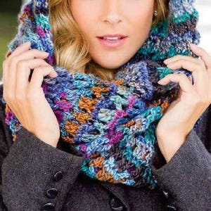 May include: A colorful crocheted cowl with a hooded design. The cowl is made with a variety of shades of blue, purple, brown, and teal yarn.