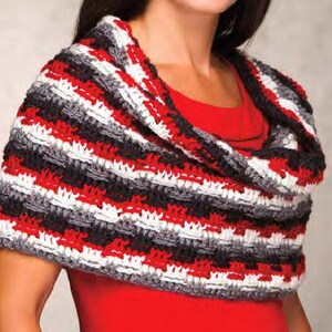 May include: A black, white, and red striped crocheted cowl with a cowl neck. The cowl is worn by a person with a red shirt.