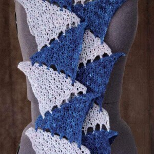 May include: A handmade crochet scarf in a triangular pattern, displayed on a mannequin. The scarf alternates between white and blue sections, creating a visually appealing design. The scarf is made of soft yarn.
