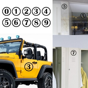 Op de afbeelding: Een set zwarte en witte nummer stickers. De nummers zijn in een cirkel met een witte achtergrond en zwarte nummers. De nummers zijn 0 tot en met 9. Er zijn ook drie voorbeelden van de stickers die worden gebruikt op een gele Jeep, een glazen deur en een locker.
