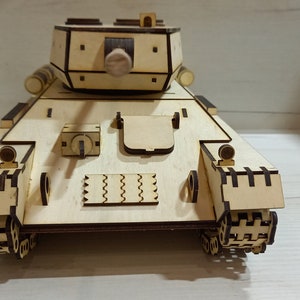 Puede incluir: Un modelo de tanque de madera, con un dise&ntilde;o detallado y un acabado marr&oacute;n. El tanque tiene una torreta con un ca&ntilde;&oacute;n y orugas en la parte inferior.