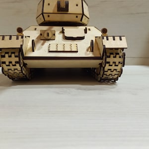 Puede incluir: Un modelo de tanque de madera, con orugas detalladas y una torreta. El modelo est&aacute; hecho de madera marr&oacute;n claro y tiene un dise&ntilde;o realista.
