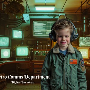 May include: A young person wearing a green jacket with an American flag patch, headphones, and a smile, standing in front of a retro-style room with multiple computer monitors and a sign that reads "Retro Comms Department - Digital Backdrop".