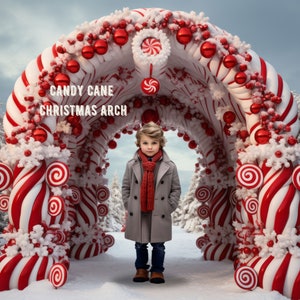 May include: A red and white candy cane archway decorated with red ornaments and white faux snow. The archway is large enough for a child to walk through. The text "CANDY CANE CHRISTMAS ARCH" is written on the archway.