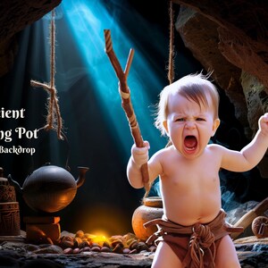 Puede incluir: Un telón de fondo digital que presenta un escenario de cueva con un bebé vestido con un taparrabos marrón y sosteniendo un palo. La cueva está iluminada por un rayo de luz y hay varios accesorios, como una olla de cocción, una tetera y un fuego.