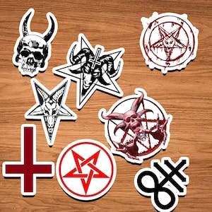 May include: A set of nine black and white stickers featuring various occult symbols, including a skull, pentagrams, and a cross. The stickers are on a wooden background.
