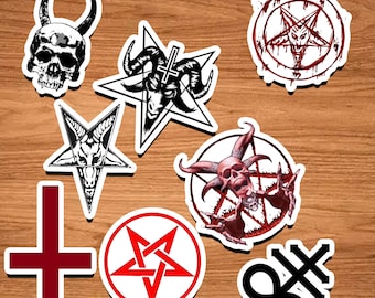 May include: A set of nine black and white stickers featuring various occult symbols, including a skull, pentagrams, and a cross. The stickers are on a wooden background.