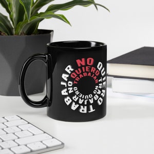 May include: Black ceramic mug with a white design that says "No quiero trabajar" in a circle. The text is in red and white.